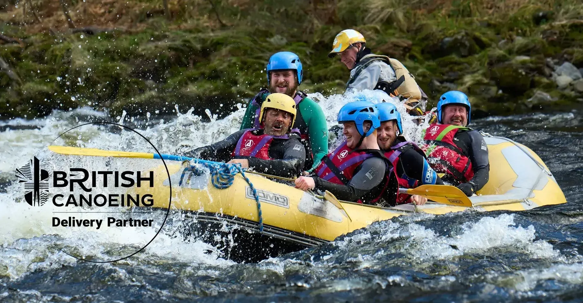 Whitewater rafters navigate a river, splashing through rapids. Several people wear helmets and life vests.
