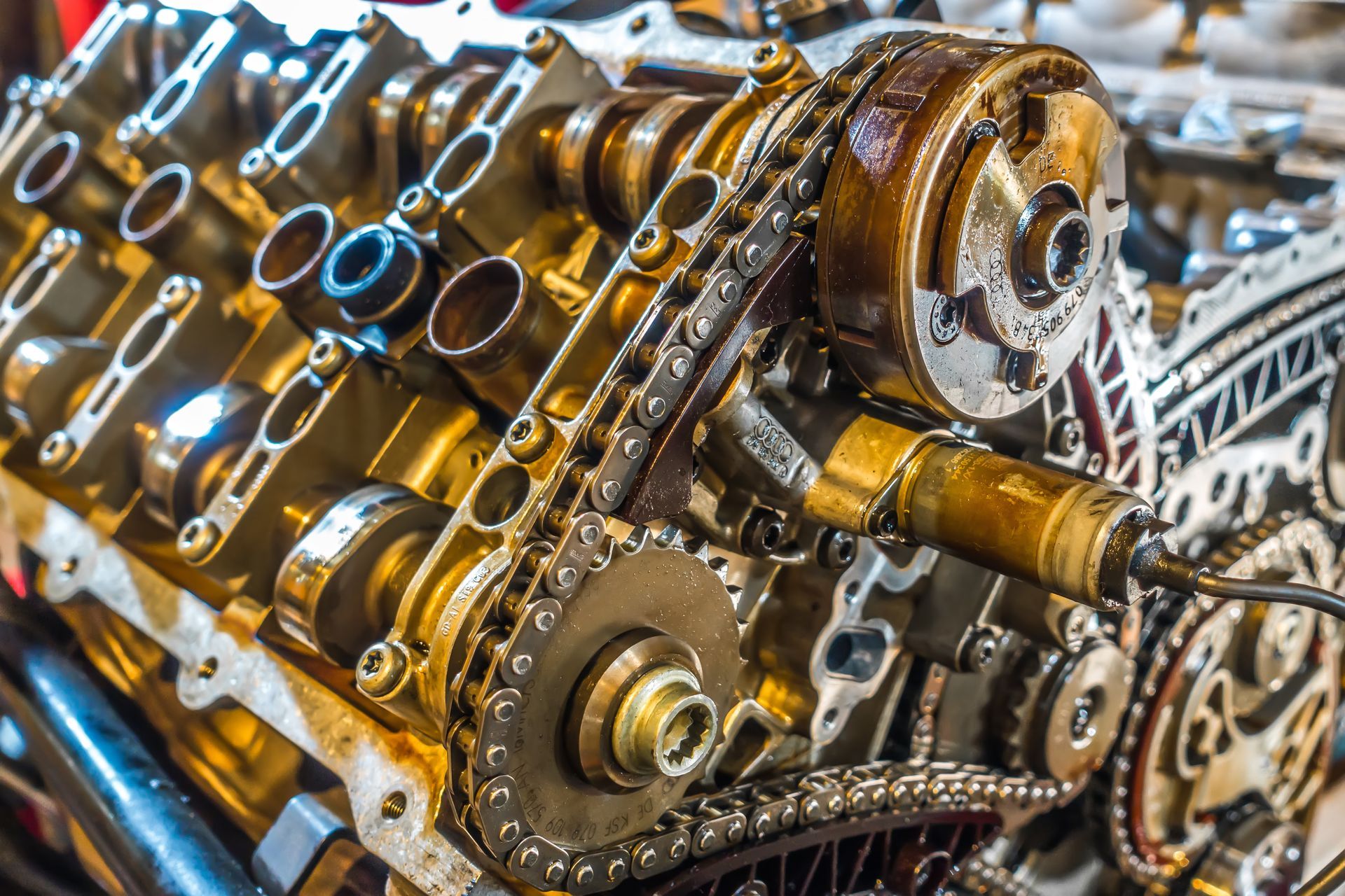 Close-up of an engine's internal components, including gears, chains, and camshafts. Visible oil