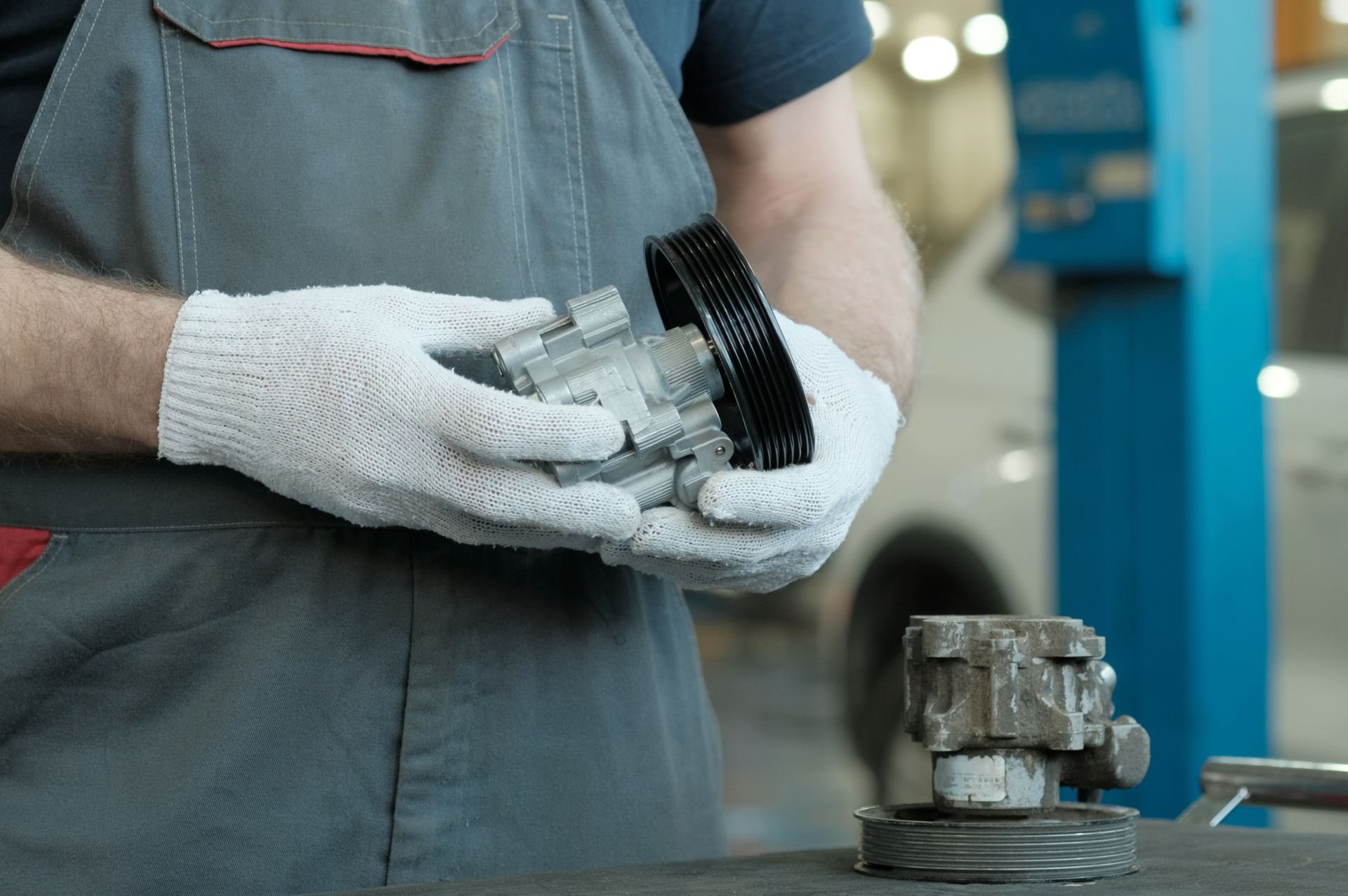 Mechanic holding a car part in a workshop.