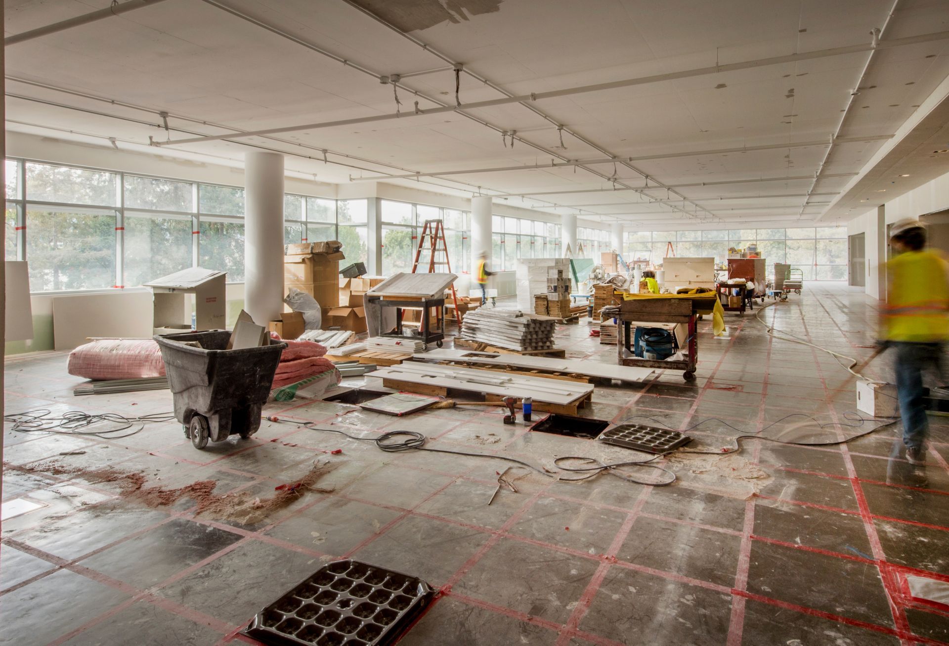 Workers in safety vests during a commercial building remodel of an open office interior