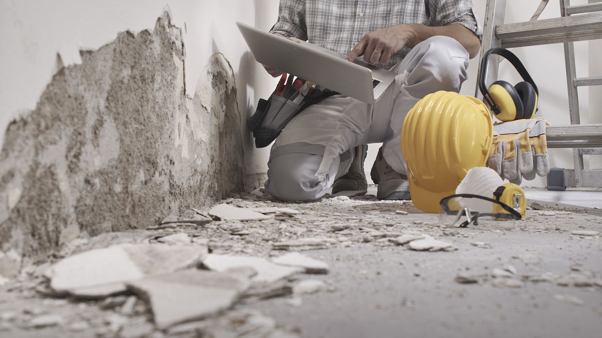 Construction team realizes restoration job on a wall, showing Elite Builds construction services in Two Rivers, WI.