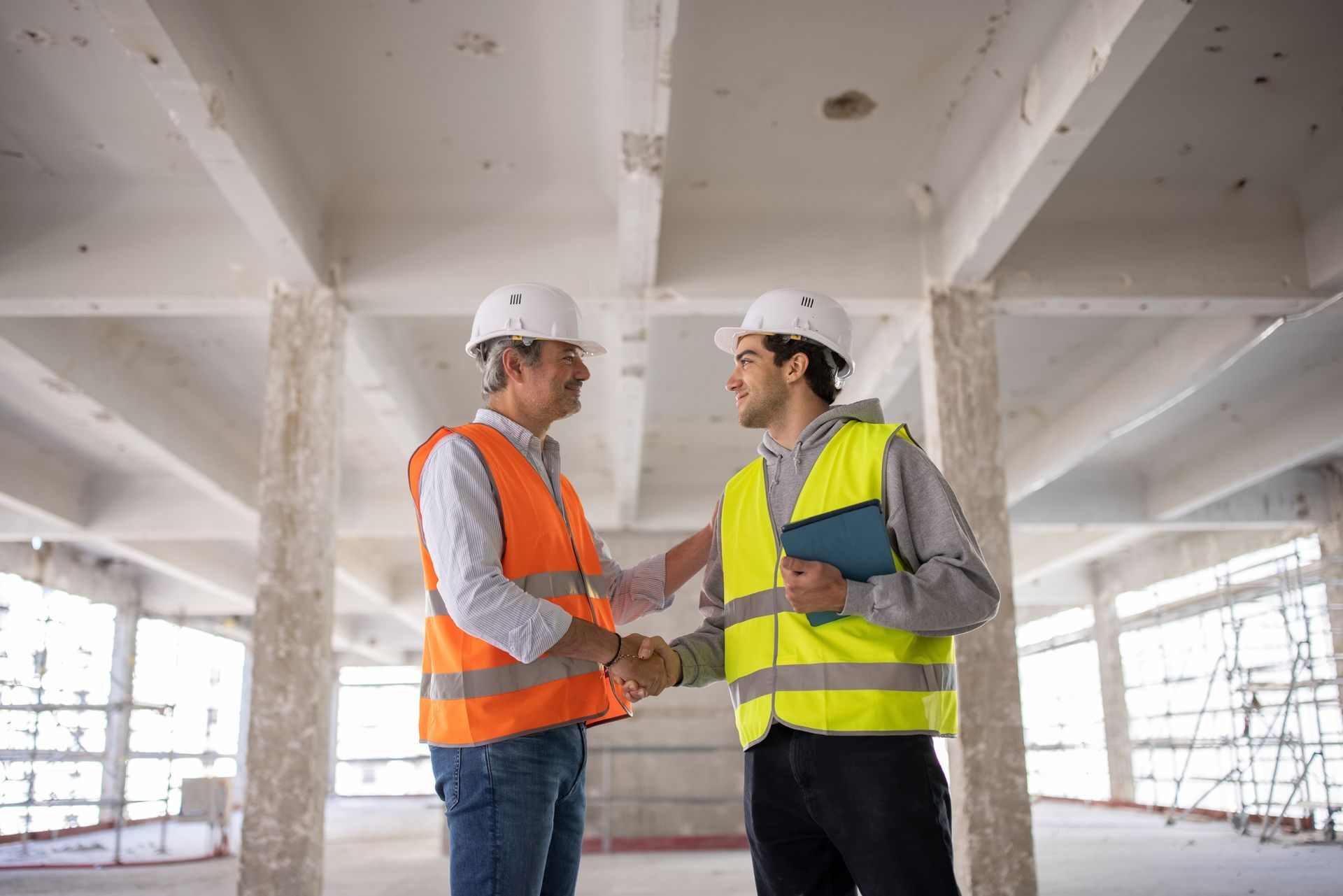 Two co-workers shaking hands as they visiting a building site.