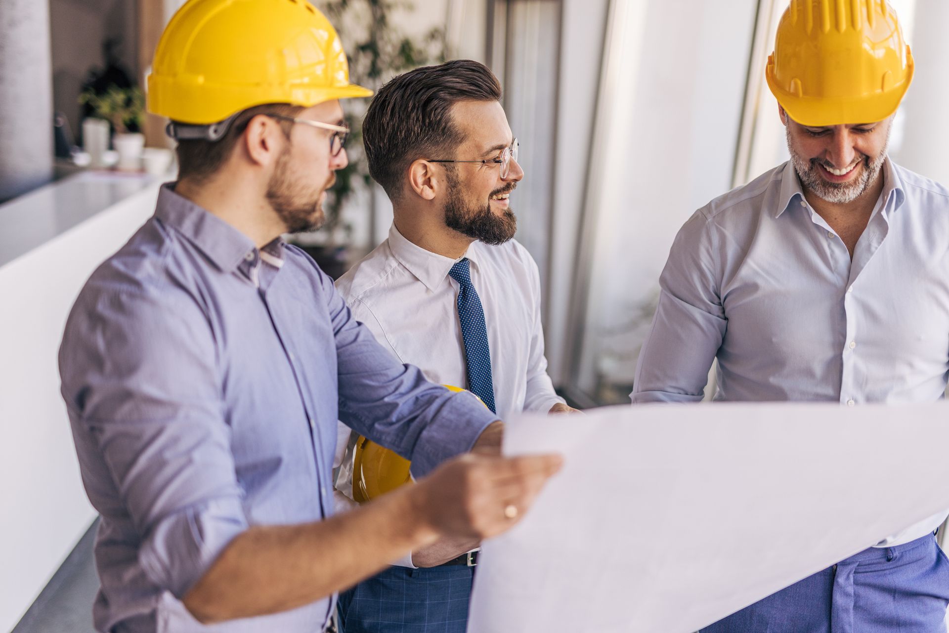 Engineers and architect discussing a blueprint in the office.