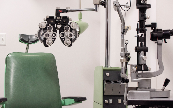 An ophthalmologist 's office with a green chair and a machine