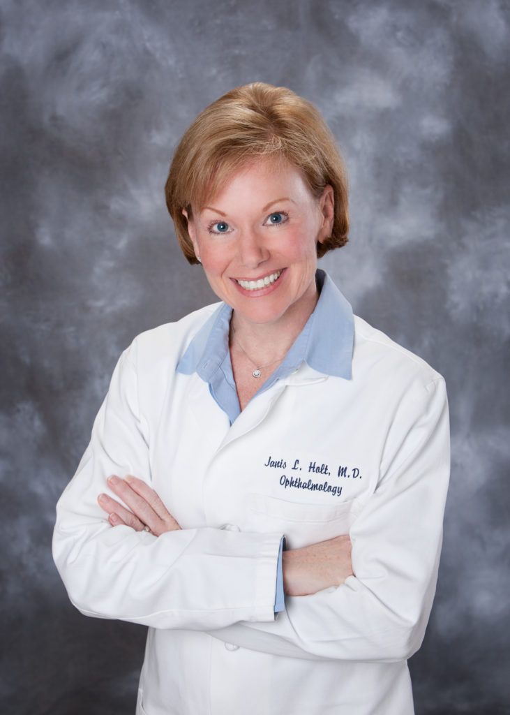 A woman wearing a white lab coat has her arms crossed