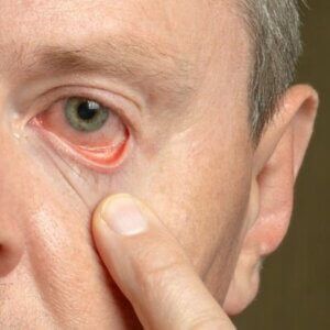 A close up of a man 's face with his finger on his nose.