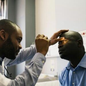 A man is getting his eyes examined by a doctor