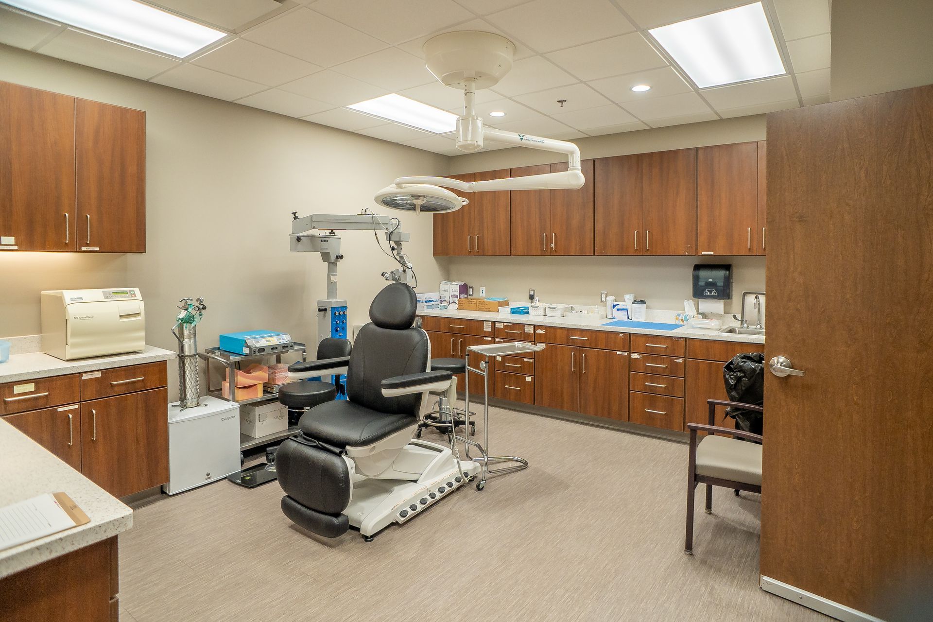 A dental office with a dental chair and a microscope.