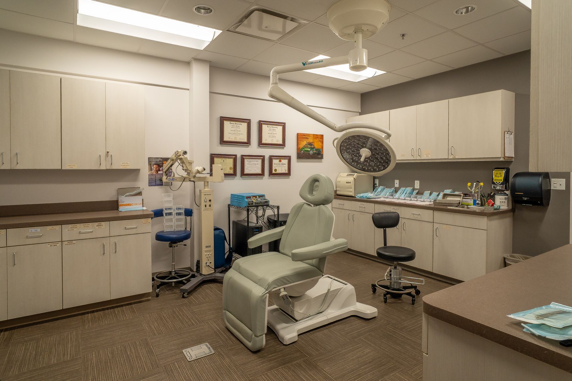 An operating room with a surgical chair and a surgical light.