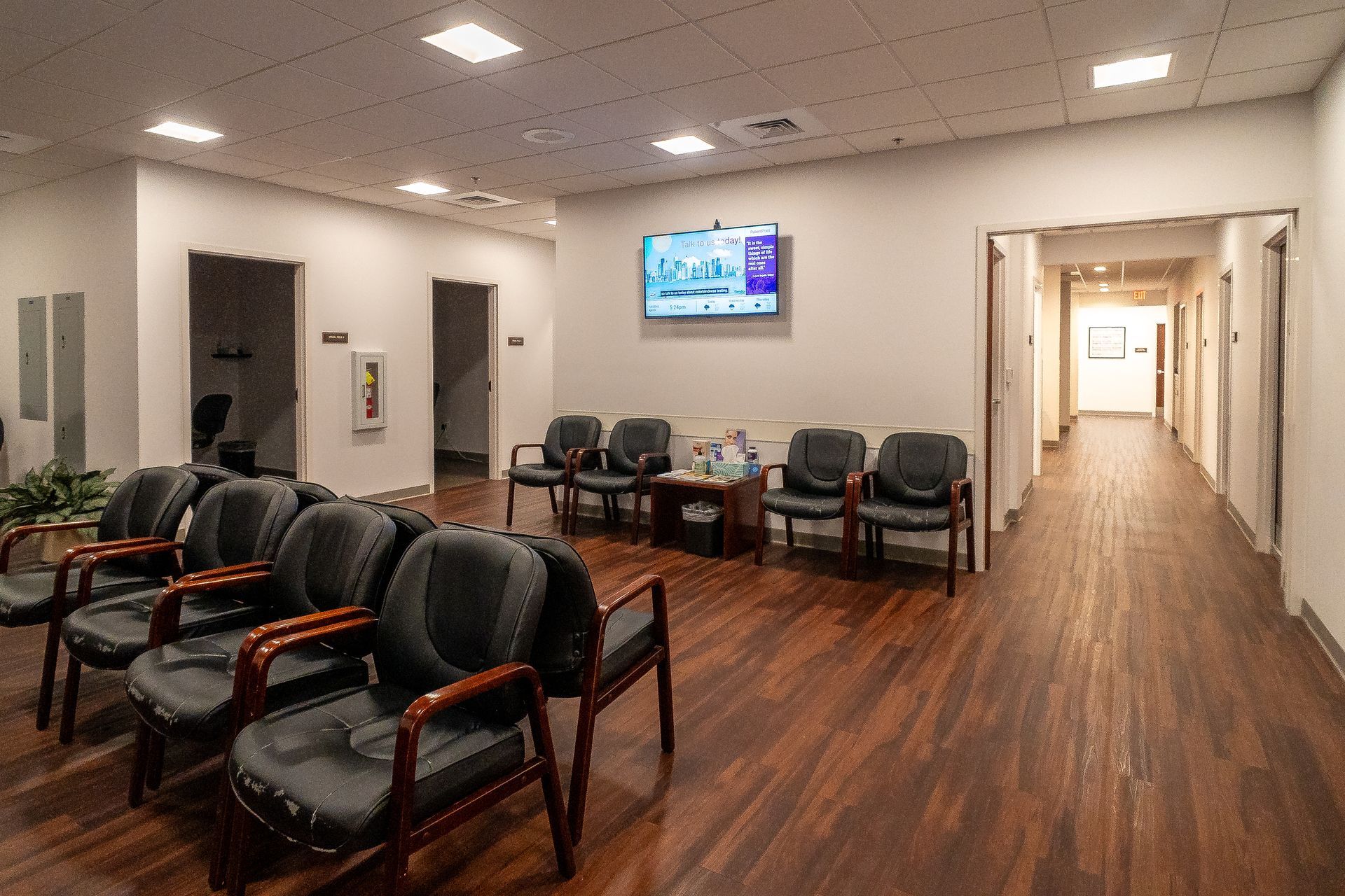 A waiting room with chairs and a television on the wall.