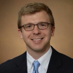 A man in a suit and tie is smiling for the camera.