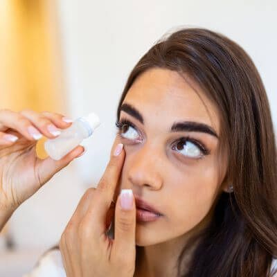 woman treating chronic dry eyes with eye drops