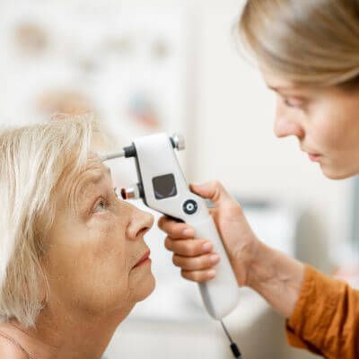 young female eye surgeons examining an older female patient