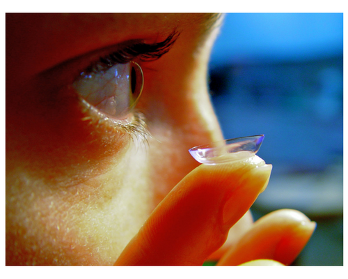 A person is putting a contact lens in their eye.