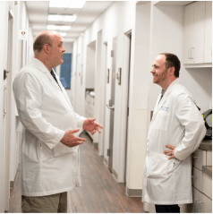 Dr. Sweet and Dr. Bodenhaimer having a conversation in a hallway
