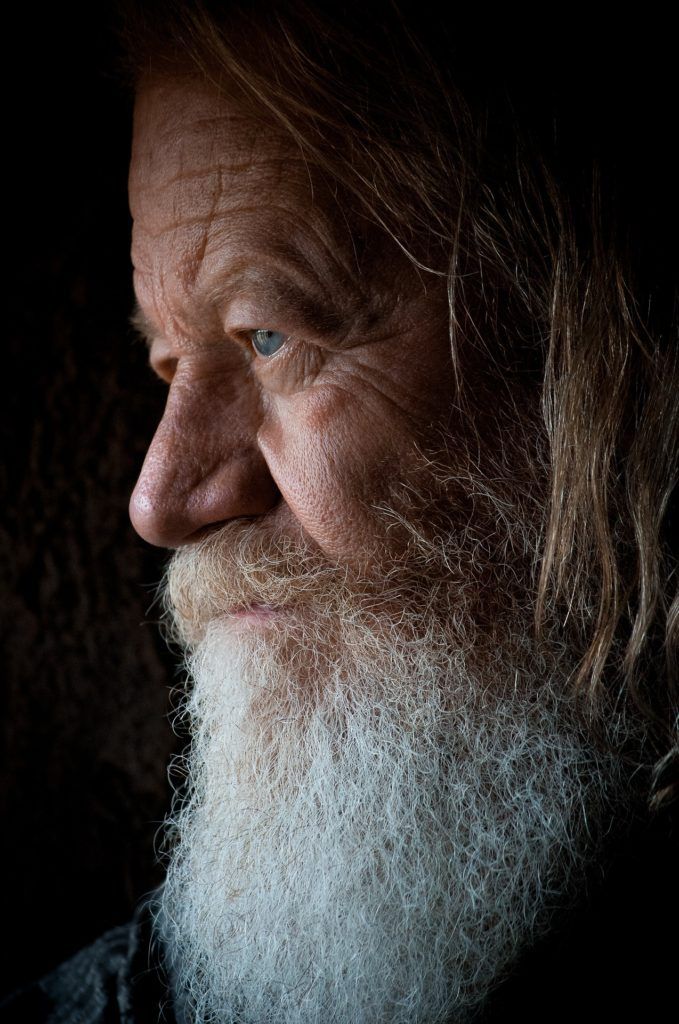 A close up of a man with a beard and long hair.