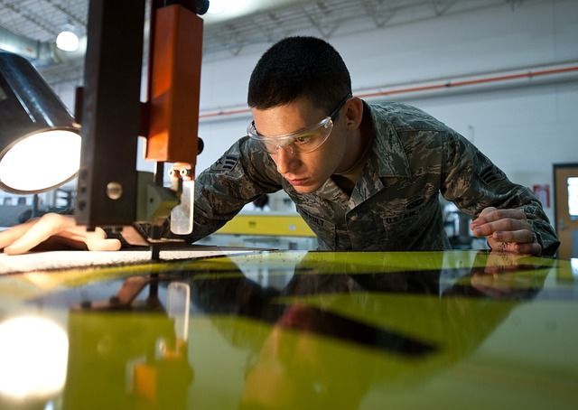 A man in a military uniform is working on a machine