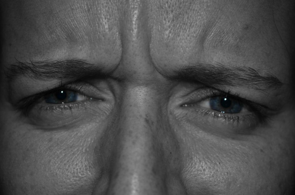 A close up of a man 's eyes with a serious look on his face.