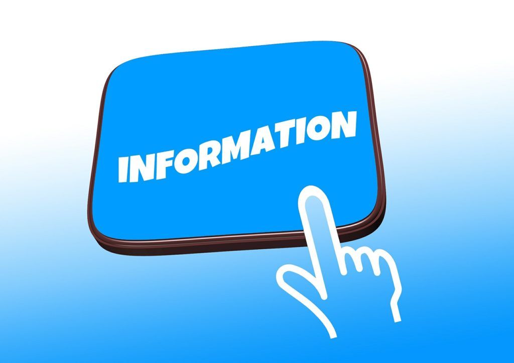 A hand is pointing at a blue sign that says information