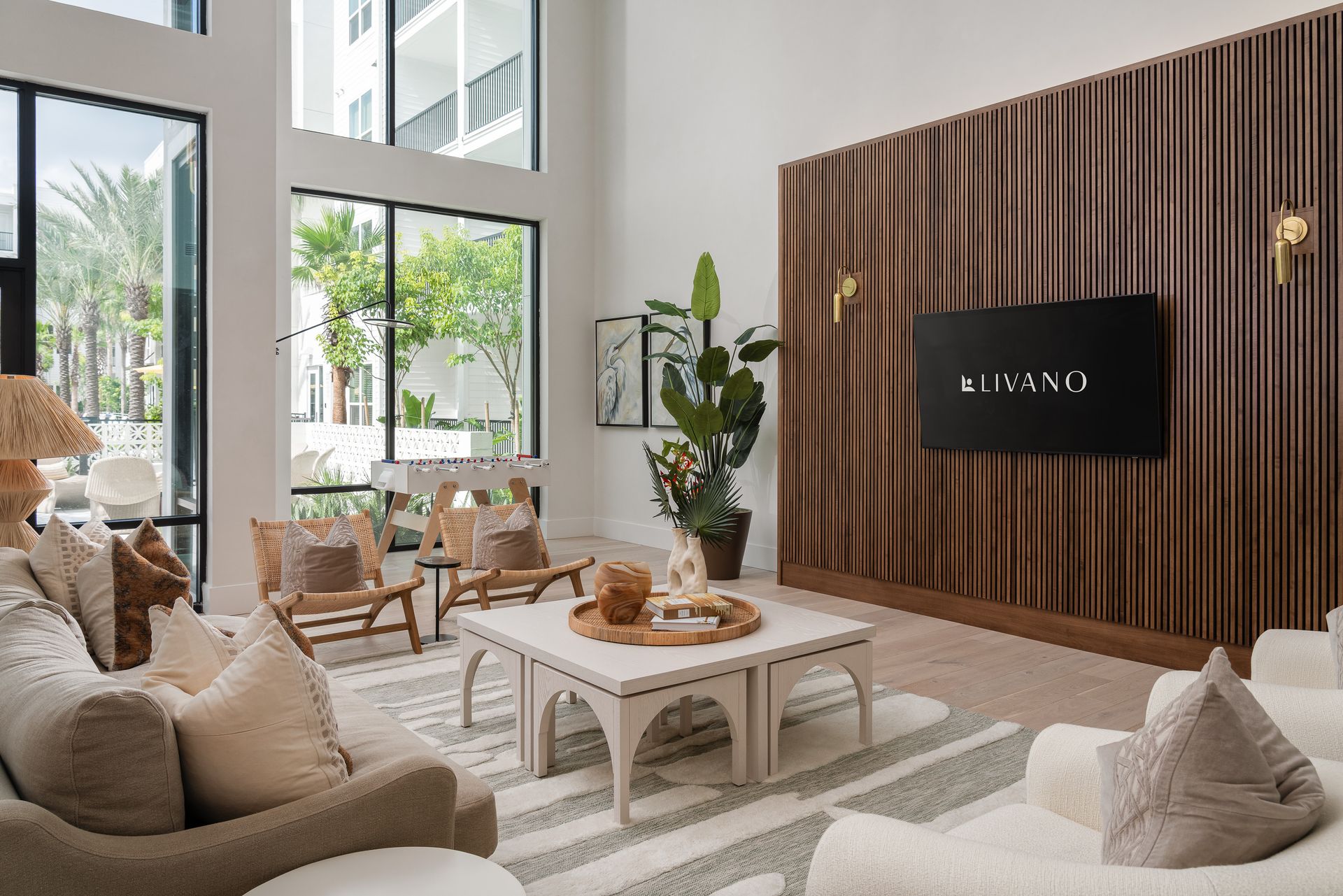 A woman sits at a table holding a glass of wine