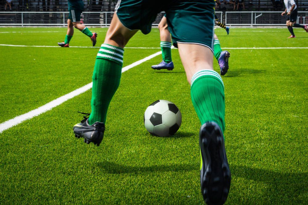 Boy Running On Grass Field In Soccer Cleats