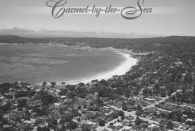 Black-and-white aerial view of Carmel-by-the-Sea coastline with bay, beach, and homes
