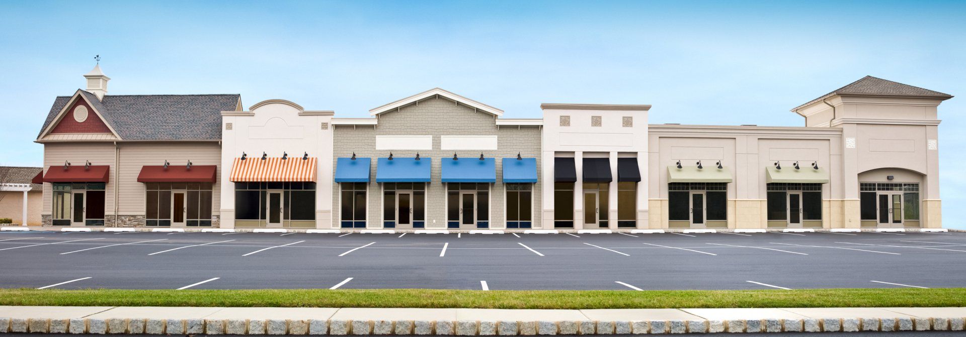 A row of buildings with awnings are lined up on the side of a road