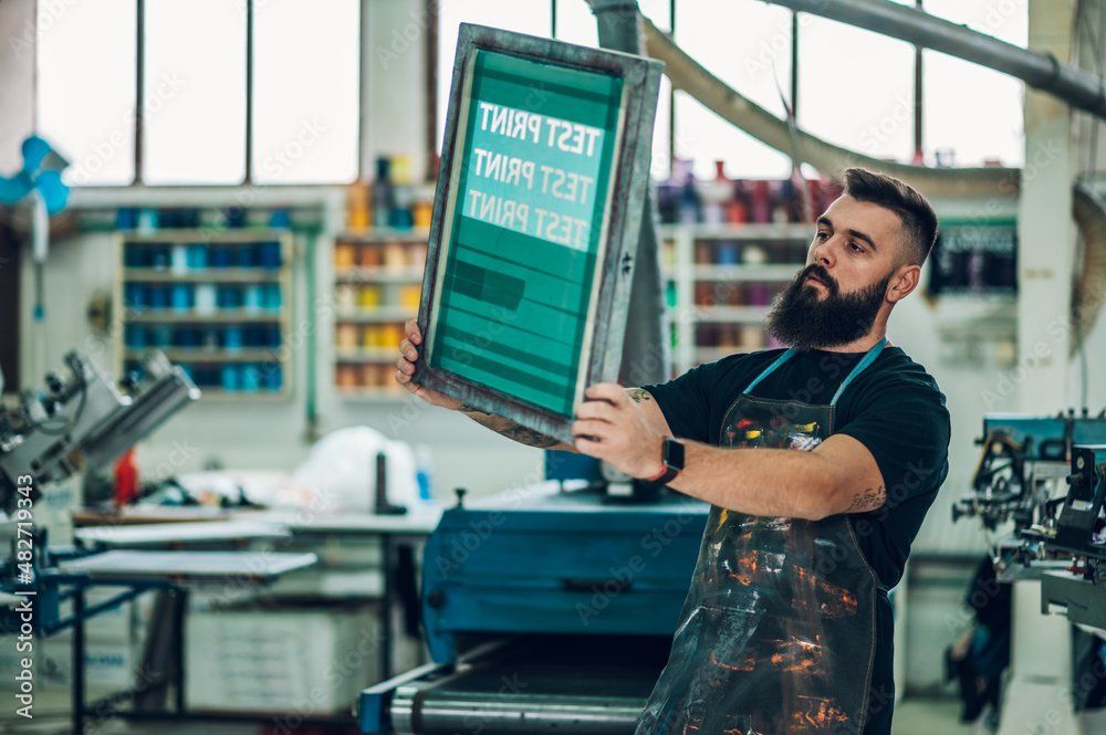 A man with a beard is holding a screen