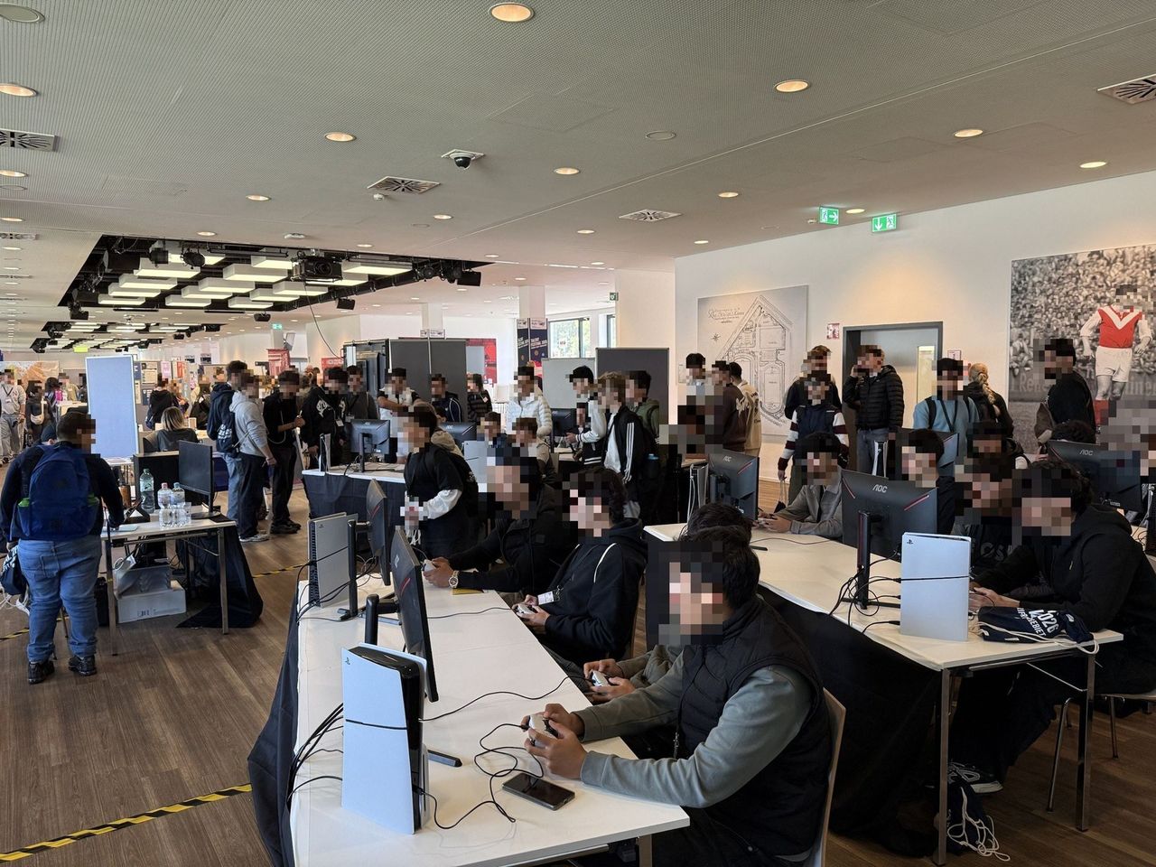 Young people playing EA FC at the fully occupied stations of the gaming booth