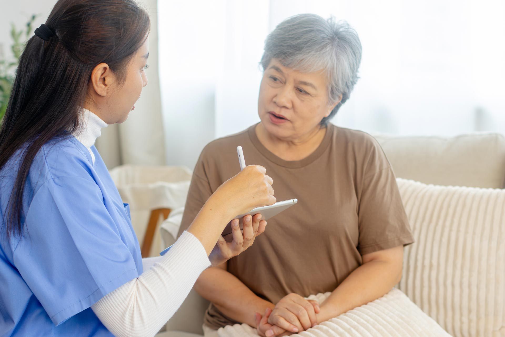 A caregiver is talking to an elderly woman. A caregiver is talking to an elderly woman.