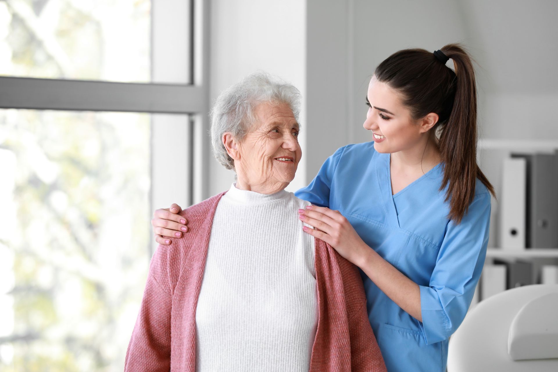 A caregiver is talking to an elderly woman.