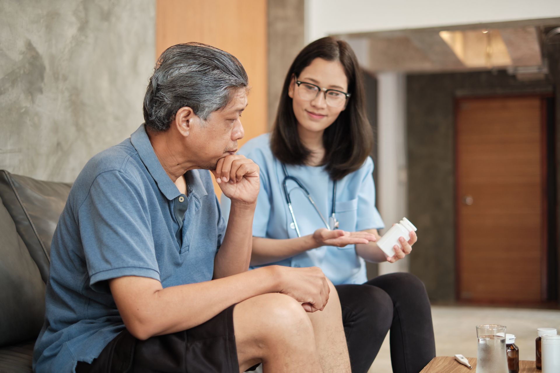 A caregiver is giving the medicine to a man.