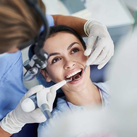 Charming young woman receiving dental treatment at clinic 