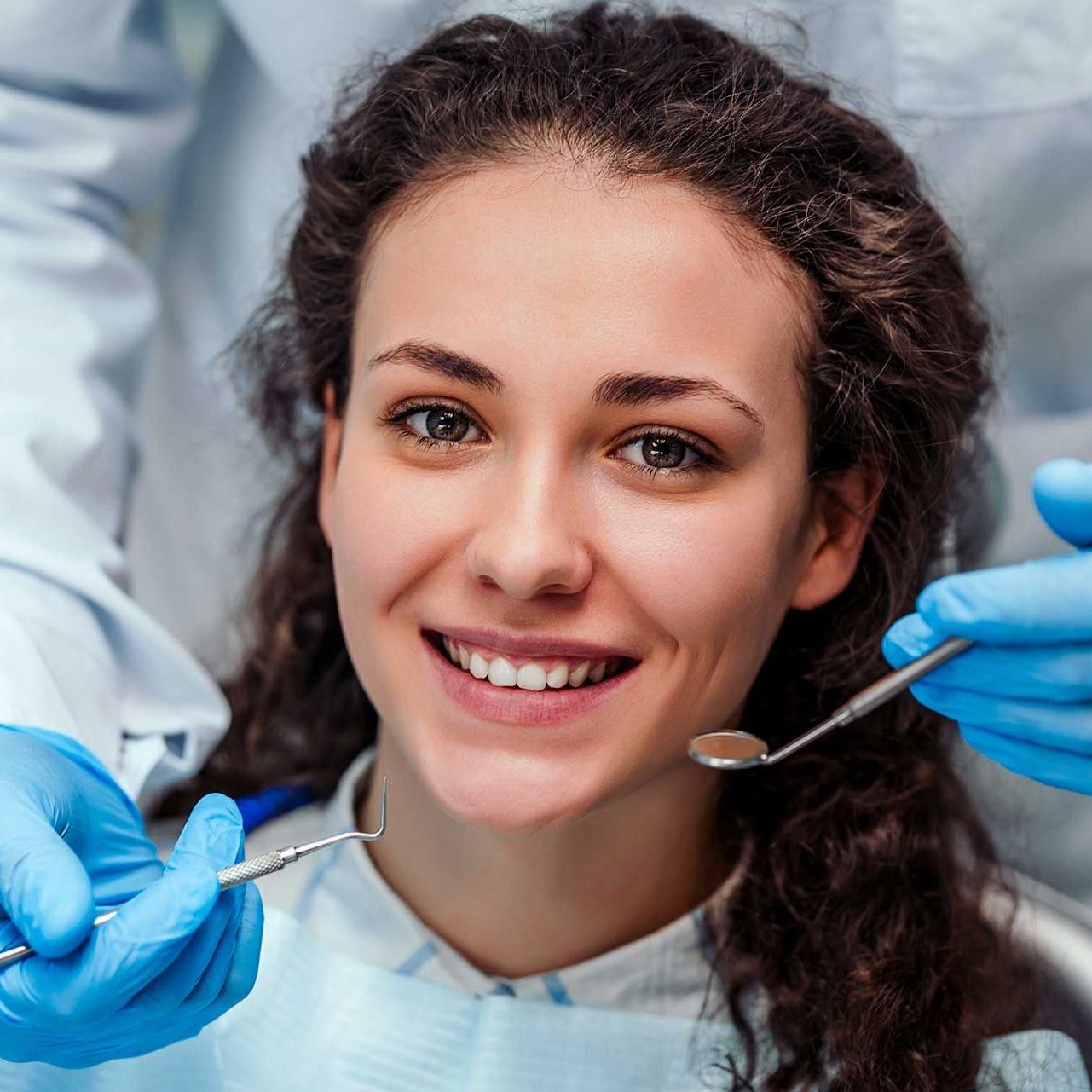 Health check. Dentist in stomatology center is making an examination of girl teeth by using dental tools. 
