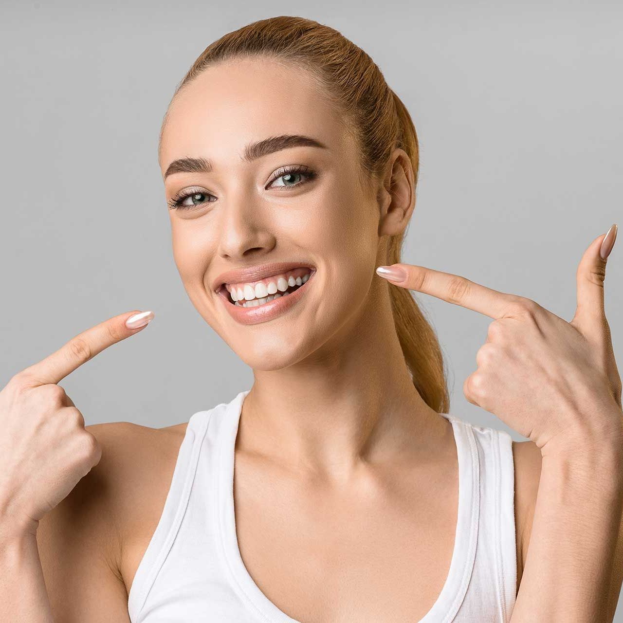 Orthodontic concept. Happy girl showing her beaming white teeth 
