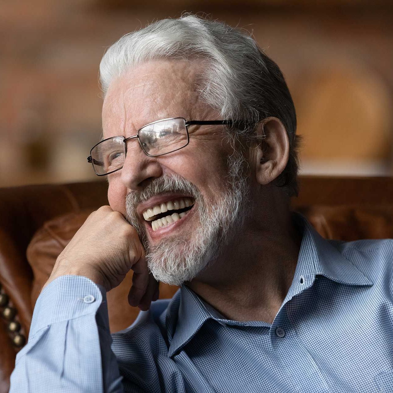 Mature aged man retiree wear glasses sit on sofa
