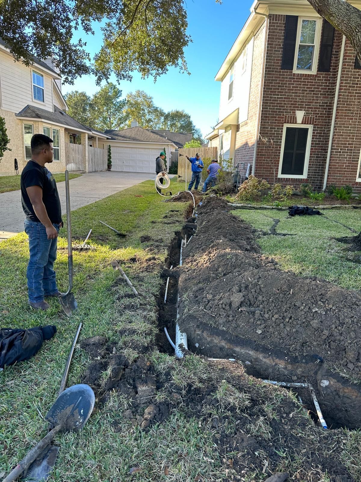 Picture of a residential plumbing repair in Katy, Texas. a trench is dug out around the house where now new plumbing is being installed. 
