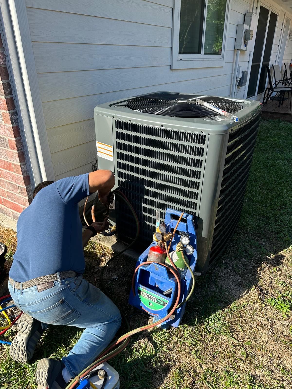 Man repairing an outside AC unit. 