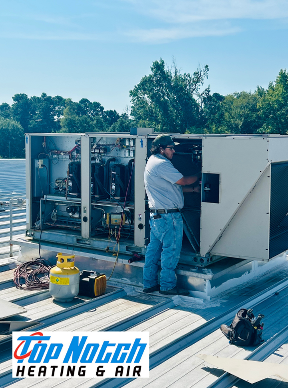 HVAC technician inspecting air conditioning units outside a building, wearing blue uniform and holding clipboard. HVAC technician inspecting air conditioning units outside a building, wearing blue uniform and holding clipboard.