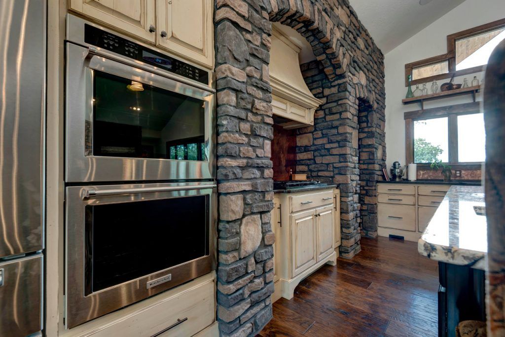 Kitchen With Stainless Steel Appliances And A Stone Wall — Willard, MO — Bill’s Custom Woodworks