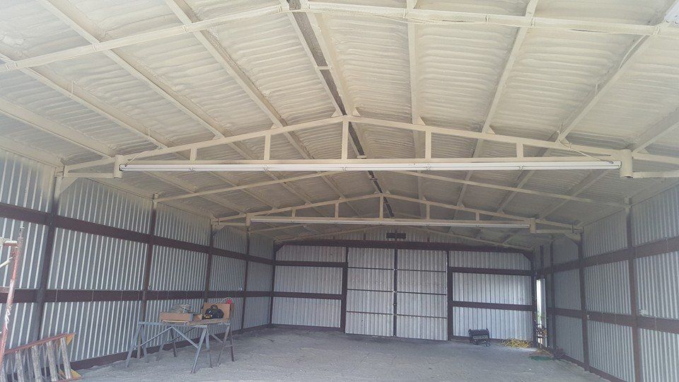 Interior of a metal shed with spray foam insulation on the roof.
