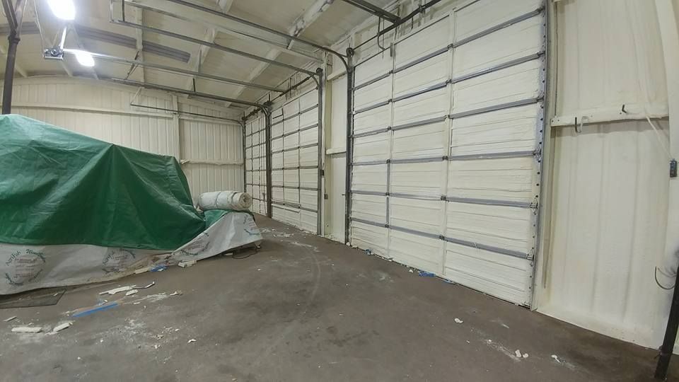 An empty industrial building with insulated walls and a covered item.