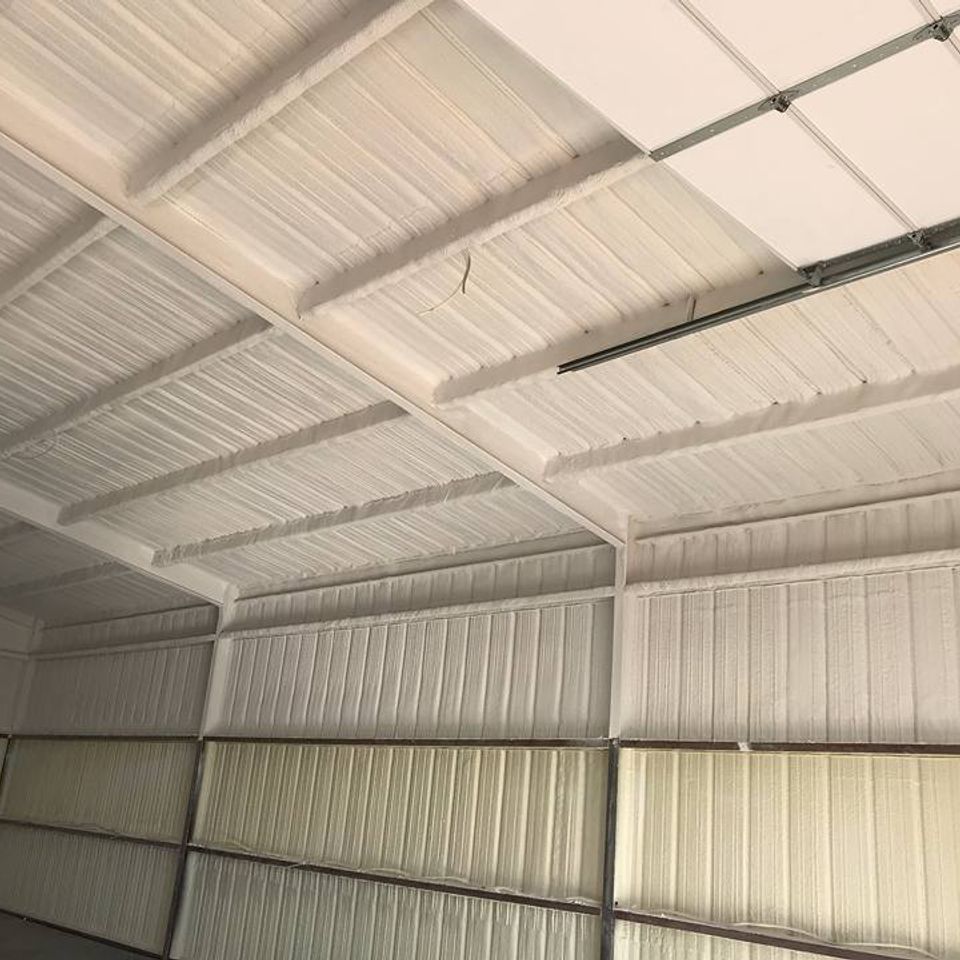 White-painted interior of a metal building. Walls and ceiling are made of corrugated metal panels.