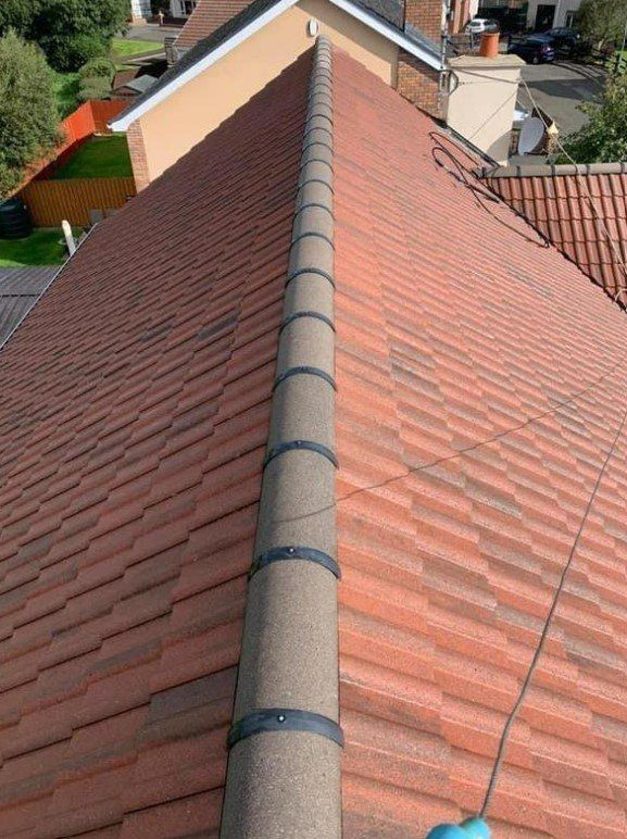 Picture of a a gable roof in dark english red tiles by Roofers Leeds