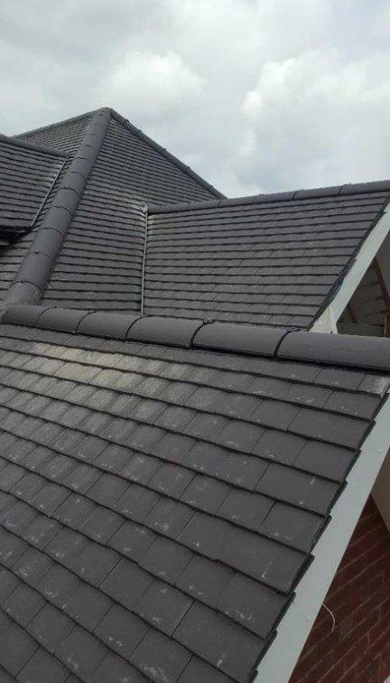 Picture of a new roof replacement with dark grey plain concrete tiles by Roofers Leeds