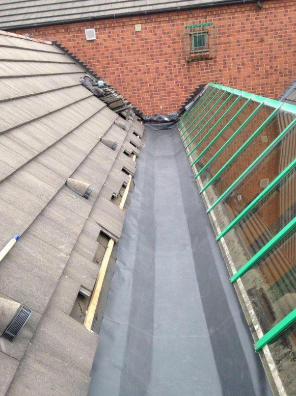 Picture of a gutter lined in lead substitute by Roofers Leeds