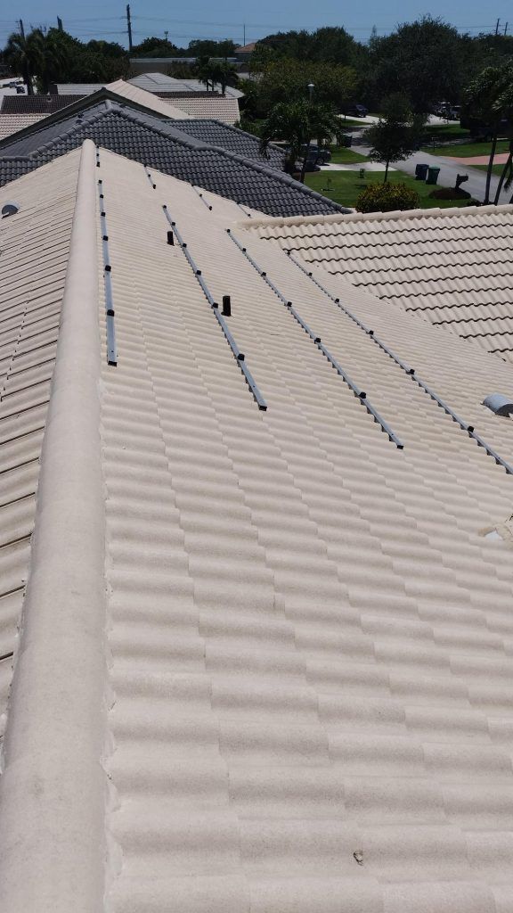 A roof with a lot of tiles on it and trees in the background.