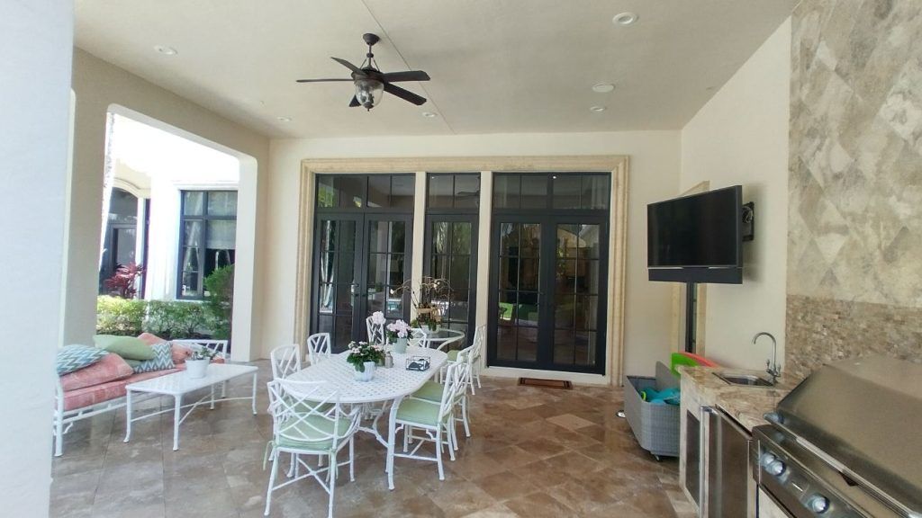 A patio with a table and chairs and a television on the wall.