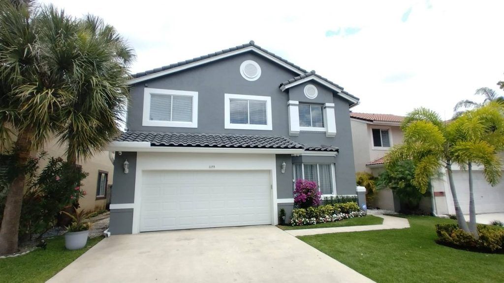 A gray and white house with a white garage door