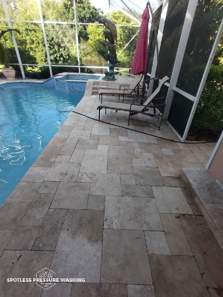 A patio with chairs and umbrellas next to a swimming pool.